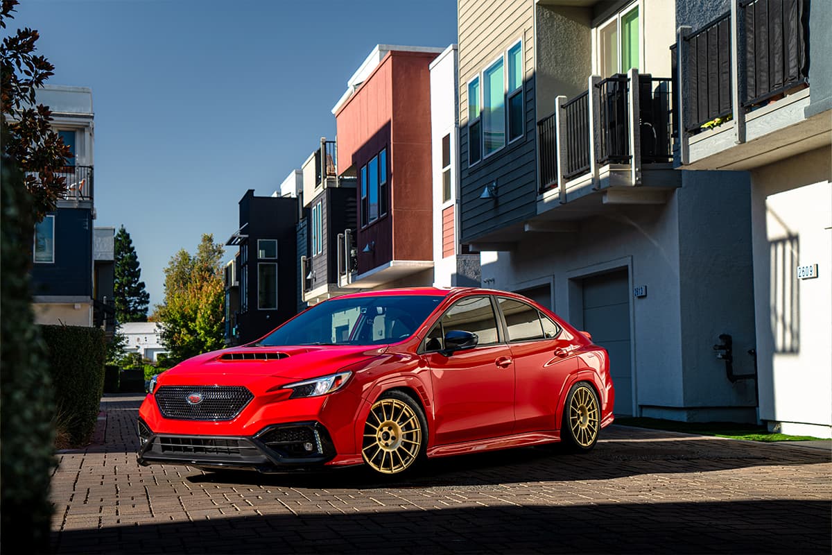 A red subaru parked in dramatic lighting